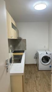 cocina con lavadora y lavadora en 布拉格城堡公寓 en Rudná