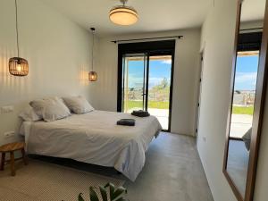 a bedroom with a bed and a large window at Villa con piscina en Golf Isla Canela Links in Ayamonte +27 photos