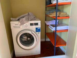 uma máquina de lavar roupa numa lavandaria com uma prateleira em Cozy Summer House Close To The Beach, em Gilleleje