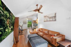ein Wohnzimmer mit einem Sofa und einem Deckenventilator in der Unterkunft Beachside Traditional Queenslander - Close to City in Machans Beach