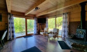 a living room with a fireplace in a wooden house at Domek na zboczu in Ochotnica Górna