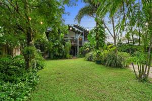 einen Hof vor einem Haus mit Bäumen in der Unterkunft Beachside Traditional Queenslander - Close to City in Machans Beach