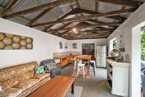 ein Wohnzimmer mit einem Sofa und einem Tisch in der Unterkunft Beachside Traditional Queenslander - Close to City in Machans Beach