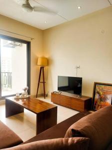 uma sala de estar com um sofá e uma mesa de centro em Premium 1bed apt CNTRL Minimal and cozy em Lahore