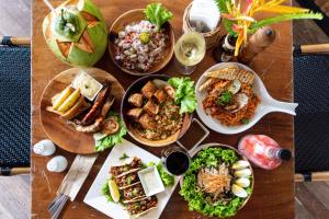 a wooden table with plates of food on it at Maremegmeg Beach Club in El Nido