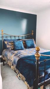 a bedroom with a bed with a blue wall at Beachfront Artsy Apartment in Clacton-on-Sea