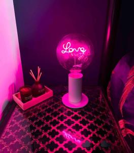 a pink lighted lamp on a table in a room at Beachfront Artsy Apartment in Clacton-on-Sea