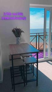 a table with a vase of flowers on a balcony at Beachfront Artsy Apartment in Clacton-on-Sea