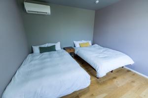 two beds in a room with blue walls at Flower Base Lily House - Vacation STAY 55464v in Fukuoka