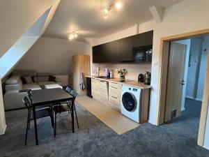 a kitchen and dining room with a table and a washing machine at Stay Adventure Mrzeżyno in Mrzeżyno