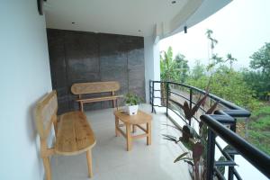 a porch with a table and chairs on a balcony at Rasha residency in Kalpetta