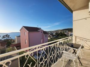 a balcony with a table and a chair and the ocean at Red Hill apartment in Zaboric