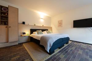 Schlafzimmer mit einem Bett und einem Flachbild-TV in der Unterkunft B&B aan het Dijksteegje in Sint-Oedenrode