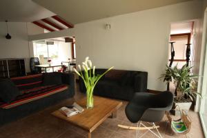 ein Wohnzimmer mit schwarzem Sofa und einem Tisch in der Unterkunft Hotel Avenida en Arica in Arica