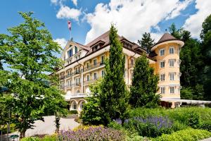 un edificio con un jardín delante de él en Le Grand Bellevue en Gstaad