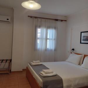 1 dormitorio con 1 cama con 2 toallas en Anastasia Hotel en Symi