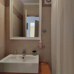 uma casa de banho com um lavatório branco e um espelho. em Anastasia Hotel em Simi