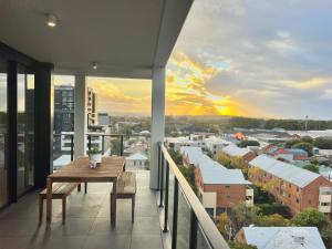 a balcony with a table and a view of a city at Harbour Towers, Newcastle's Luxe Apartment Stays in Newcastle