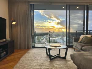 a living room with a couch and a table at Harbour Towers, Newcastle's Luxe Apartment Stays in Newcastle