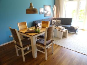 a dining room table and chairs in a living room at Gode Wind Quartiere 2 in Dahme