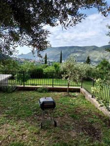 a grill sitting in the grass near a fence at Apartman Sofija HN in Herceg-Novi