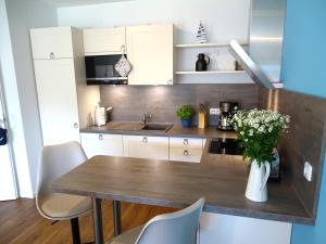a kitchen with a table and a vase of flowers at Gode Wind Quartiere 5 in Dahme