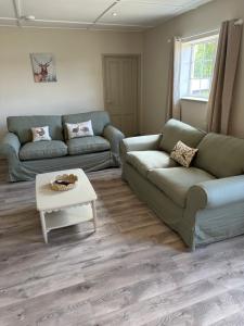 a living room with a couch and a table at The Jockey's Lodge @ Danebury in Stockbridge