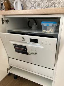 a kitchen drawer with a dishwasher in a cabinet at Apartmány Betica in Nesvady