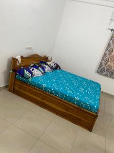 Belle villa : سرير خشبي مع شراشف زرقاء في الغرفة