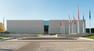um grande edifício com bandeiras à sua frente em La colline aux oiseaux em Caen