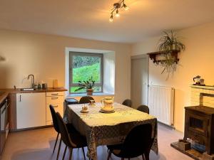 a kitchen and dining room with a table and chairs at Eole - Fermette typique Ardennaise in Sainte-Ode