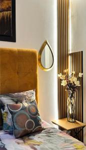 パリにあるLuxury Studio design by KENZOの花瓶と鏡付きのベッドが備わるベッドルーム1室