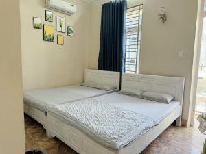 two twin beds in a room with a window at Homestay tiên tri 01 in Ly Son