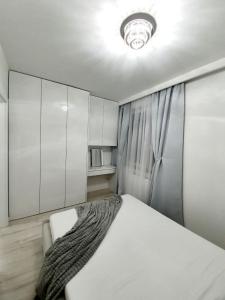 um quarto com uma cama branca e uma janela em Apartament w Centrum em Grodzisk Mazowiecki