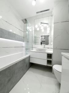 uma casa de banho branca com um lavatório e um WC em Apartament w Centrum em Grodzisk Mazowiecki