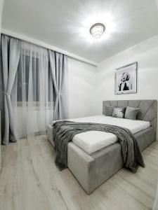 um quarto branco com uma cama grande e cortinas em Apartament w Centrum em Grodzisk Mazowiecki