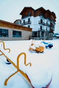 un aparcamiento cubierto de nieve frente a un edificio en Loft Hotel Bakuriani, en Bakuriani