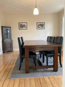 a dining room with a wooden table and leather chairs at Holiday Home In Poulsker in Neksø