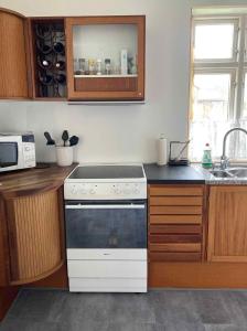 a kitchen with a white stove and a sink at Holiday Home In Poulsker in Neksø