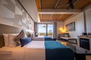 a bedroom with a bed and a living room at Maremegmeg Beach Club in El Nido