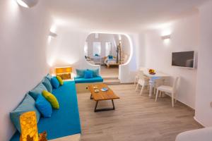 a living room with a blue couch and a table at Vivid Caves 2 Bedroom Cavehouse in Foinikiá
