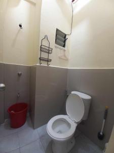 a bathroom with a toilet and a red bucket at Condo for Rent - Cagayan de Oro in Cagayan de Oro