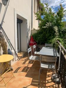 a patio with a table and chairs on a balcony at Maison Face aux Remparts in Aigues-Mortes