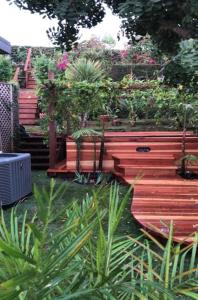 a garden with a wooden fence with potted plants at The Green Ginger Guest House in Los Angeles