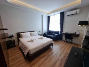 1 dormitorio con 1 cama, 1 silla y 1 sofá en Play Poshtel & Cafe' en Krabi