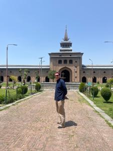 a man standing on a brick road in front of a building at The Light House in Srinagar