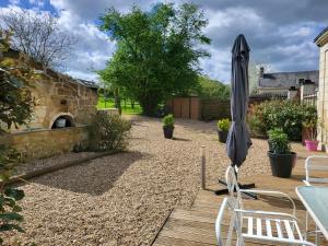 a patio with a table and an umbrella at Gite Le Charme in Cinais