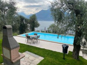 einen Pool mit einem Tisch und Stühlen neben in der Unterkunft Casa Maya in Brenzone sul Garda