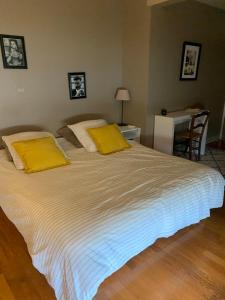 a bedroom with a large bed with yellow pillows at Maison Face aux Remparts in Aigues-Mortes