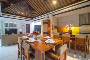une salle à manger et une cuisine avec une table et des chaises dans l'établissement Rekso Villa, à Jimbaran